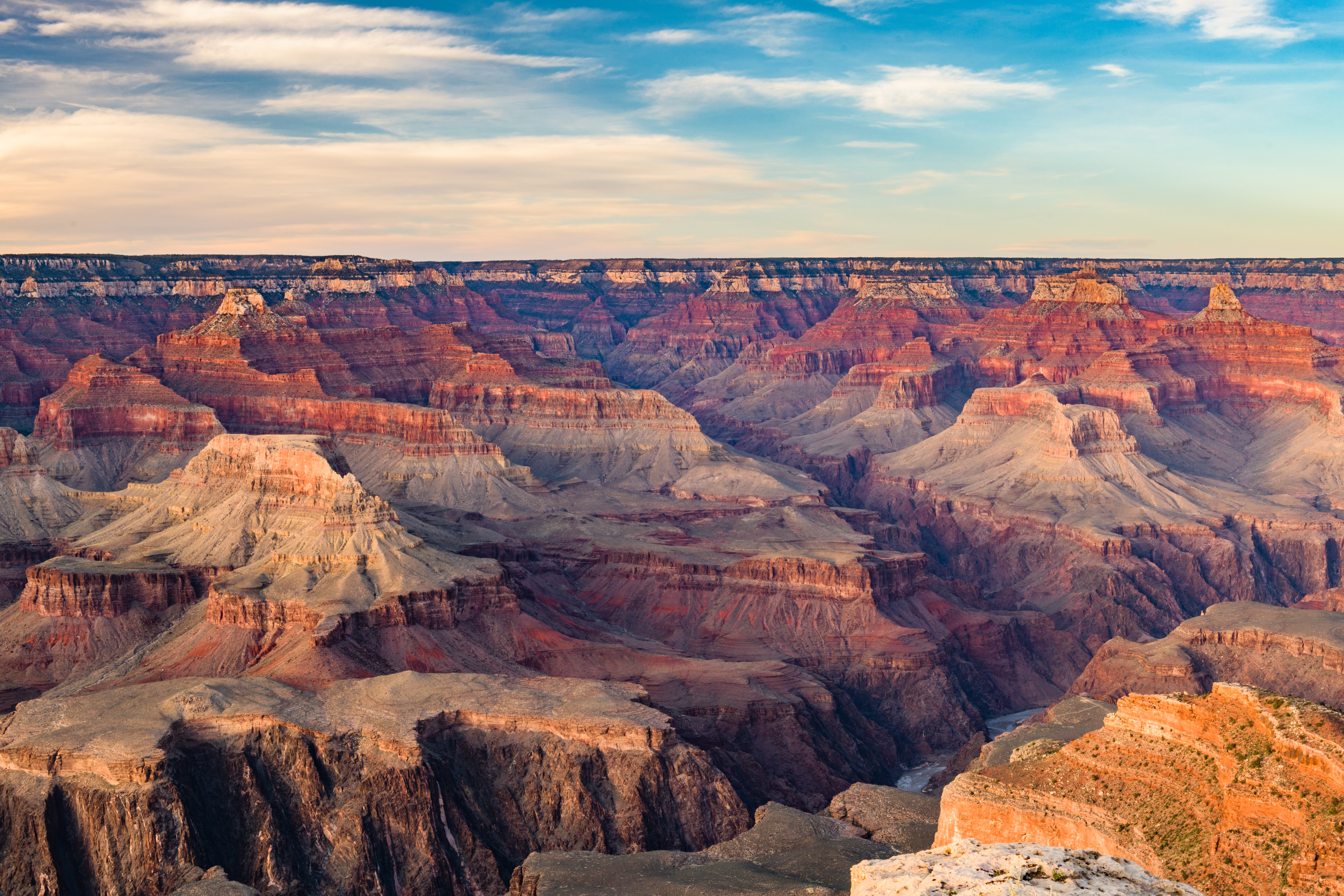 Canyon roccioso immerso nella luce calda, orizzonte ampio e cielo aperto